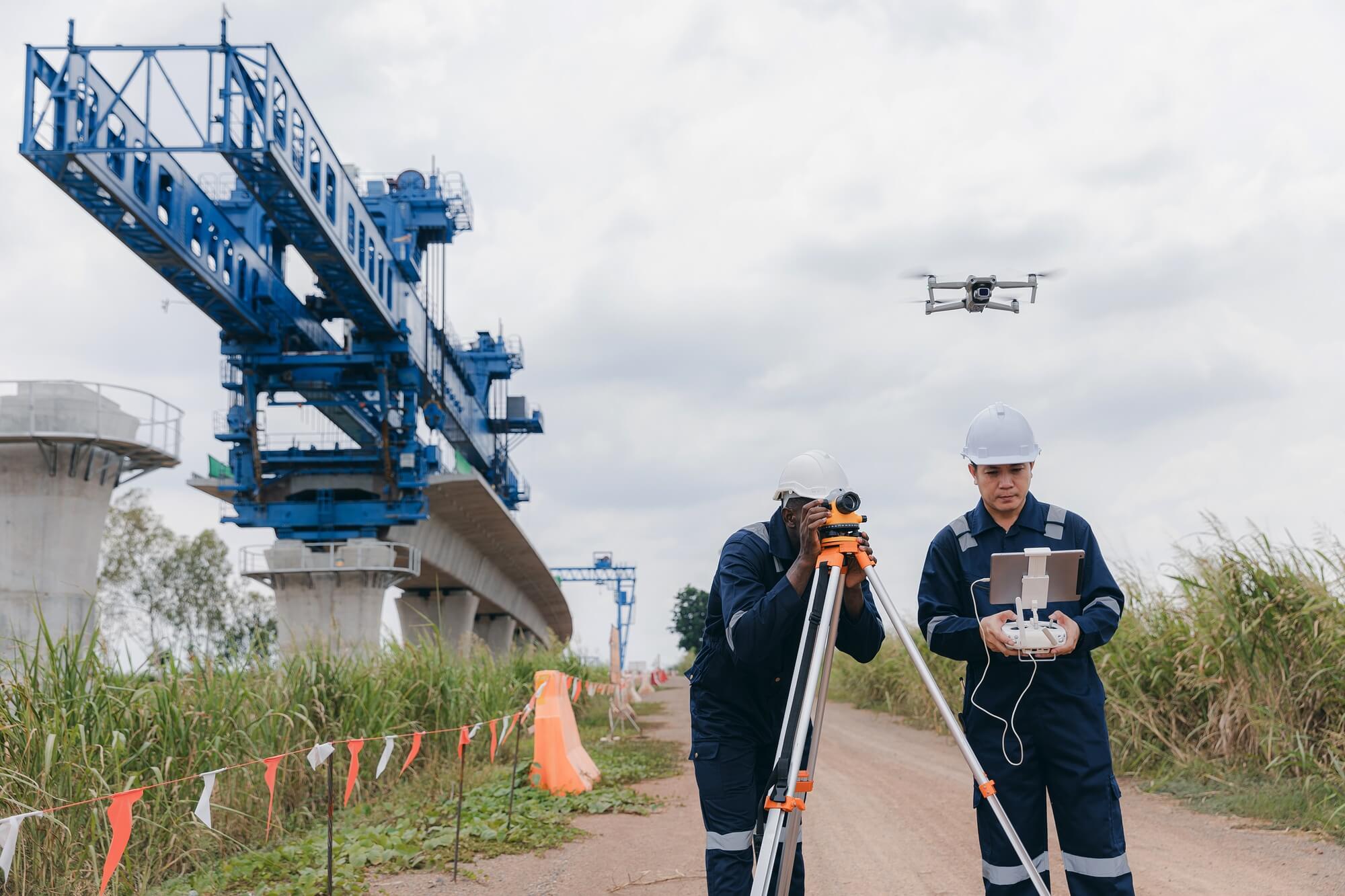 Ingineri supraveghează construcția unui pod cu dronă.